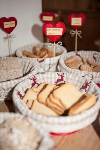 a table topped with baskets of pastries and hearts at B&B Col Da La Vila in Canazei