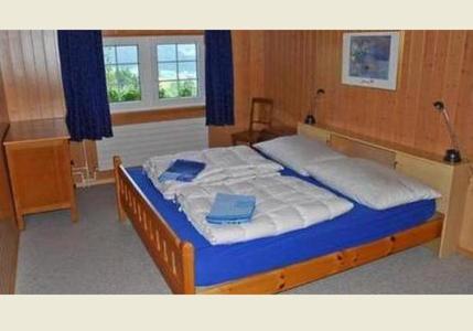 1 dormitorio con 1 cama grande con almohadas azules en Ferienhaus Brand, en Gais