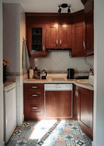 a kitchen with wooden cabinets and a stove top oven at Casa de Manuel in Pinos Genil