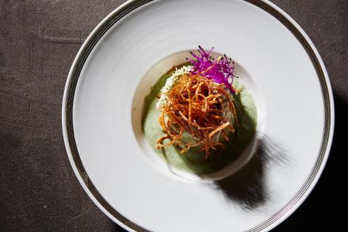 a white plate with a green avocado with vegetables on it at 山人 Oga in Oga