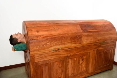 a man laying his head on top of a wooden cabinet at Mandara Rosen Yala, Kataragama in Kataragama