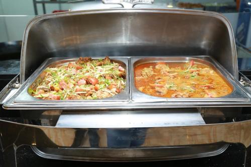 two trays of food in a pan in an oven at Al Jazeera Royal Hotel in Abu Dhabi