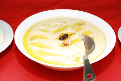 a white bowl of soup with a spoon at Al Jazeera Royal Hotel in Abu Dhabi