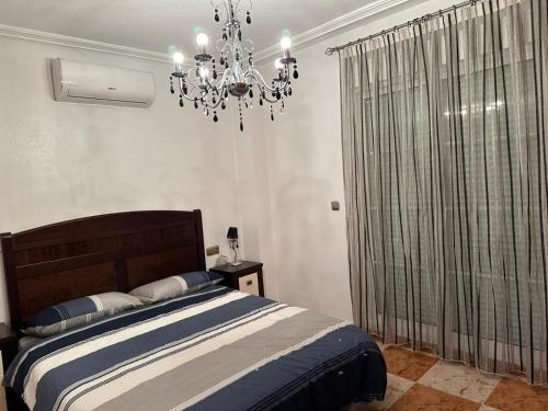 a bedroom with a bed and a chandelier at Playa Golf II Campoamor in Los Dolses