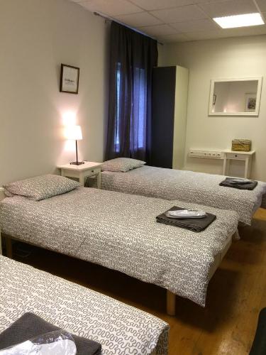 a room with two beds and a table with a lamp at Kalda Guesthouse in Haapsalu
