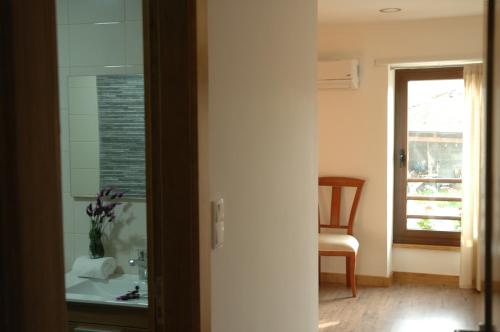 een badkamer met een wastafel, een stoel en een raam bij Casa de l Telar in Duas Igrejas