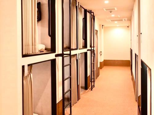 a hallway with a row of windows in a room at HOTEL minimumms女性専用カプセルホテルWomen only hotel in Naha