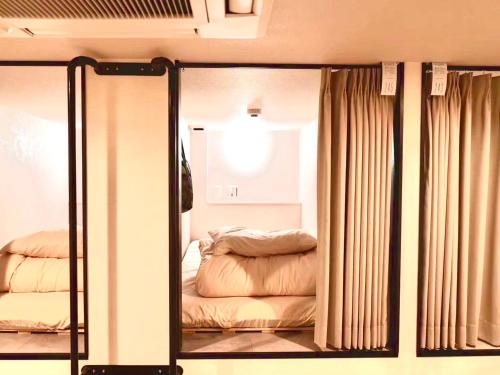 a mirror with a reflection of a bed in a room at HOTEL minimumms女性専用カプセルホテルWomen only hotel in Naha