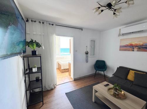 a living room with a couch and a table at Seaside Vacation in Haifa