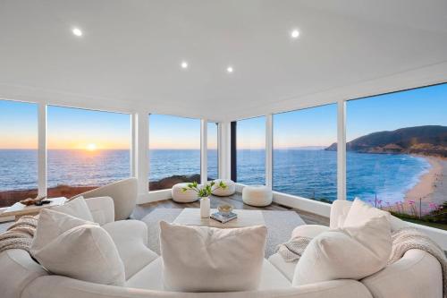a living room with a white couch and views of the ocean at Distinguished Oceanfront Point Estate with Iconic Beach Mountain Vistas in Montara