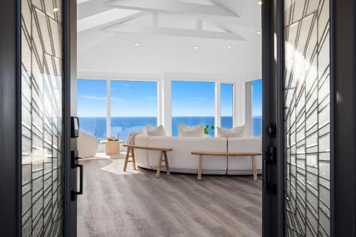 a living room with a couch and a table at Distinguished Oceanfront Point Estate with Iconic Beach Mountain Vistas in Montara
