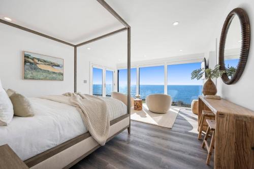 a bedroom with a bed with a view of the ocean at Distinguished Oceanfront Point Estate with Iconic Beach Mountain Vistas in Montara