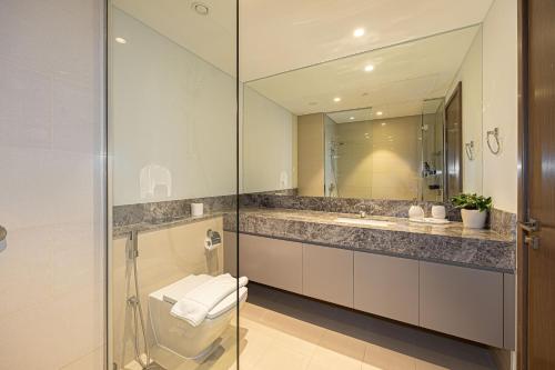 迪拜Brand new 2BR in Downtown 5 min walk to Burj Khalifa的浴室里有洗手池、马桶和镜子。