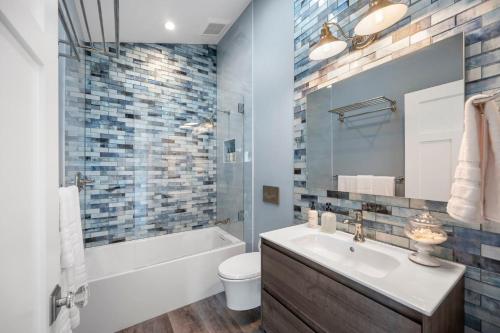 a bathroom with a sink and a tub and a toilet at Distinguished Oceanfront Point Estate with Iconic Beach Mountain Vistas in Montara