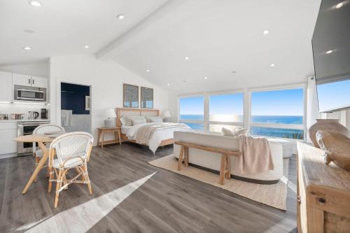 a living room with two beds and a view of the ocean at Distinguished Oceanfront Point Estate with Iconic Beach Mountain Vistas in Montara
