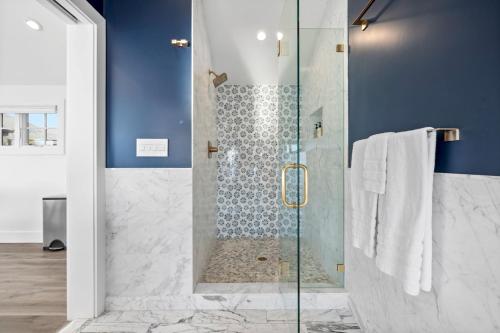 a bathroom with a shower with a glass door at Distinguished Oceanfront Point Estate with Iconic Beach Mountain Vistas in Montara