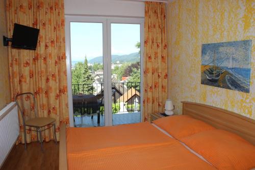 1 dormitorio con cama y ventana grande en Haus Luca Seeblick, en Pörtschach am Wörthersee