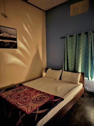 a bed in a bedroom with green curtains at Assam Villa - by Storyweavers Retreat in Jorhāt