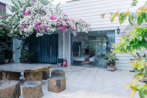 a patio with a stone bench and flowers at Window Homestay in Kon Tum