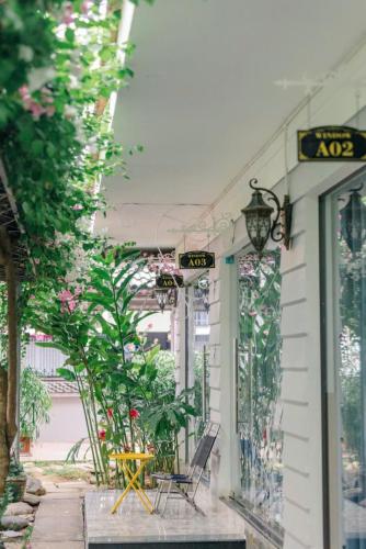a building with chairs and plants outside of it at Window Homestay in Kon Tum