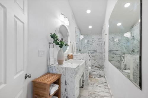 a white bathroom with a sink and a shower at Distinguished Oceanfront Point Estate with Iconic Beach Mountain Vistas in Montara