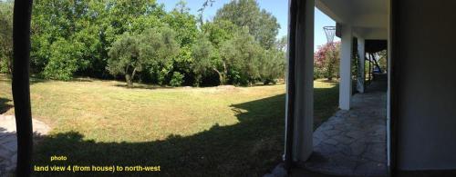 a view of a yard with trees and a building at Secluded 1.8 acre garden Villa, for exclusive use with Stunning Views. in Kalandra