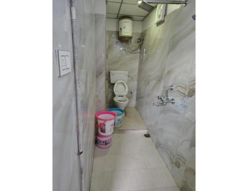 a small bathroom with two toilets and buckets in it at Hotel Guru International Andaman in Aberdeen