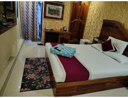 a bedroom with a bed with a blanket on it at Hotel Guru International Andaman in Aberdeen