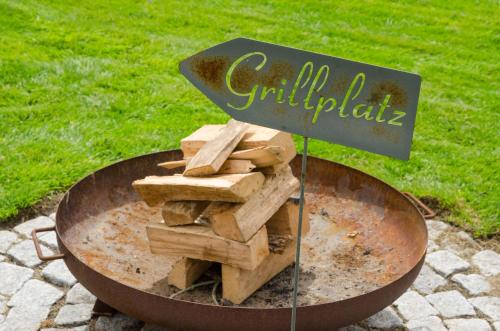 a fire pit with a pile of fire wood at Ferienwohnung Nordbrock, 65317 in Moormerland