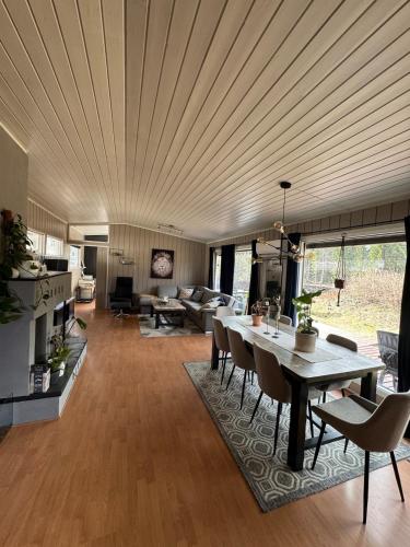 a living room with a wooden ceiling and a table at Sentral familievennlig enebolig in Åmot