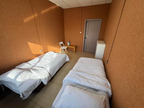 a room with two beds and a chair in it at Summer hostel in Ulaanbaatar