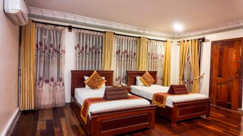 a bedroom with two beds and curtains at Okay Boutique Hotel in Phnom Penh