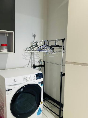 a washing machine in a room next to a refrigerator at KL suites by Nomad in Kuala Lumpur
