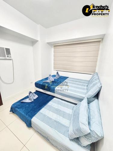 two beds in a room with blue sheets at Rawsons Crib 2Bedroom Unit in Horizons 101 in Cebu City