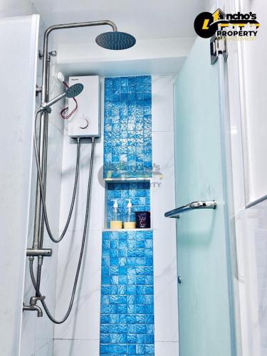 a shower in a bathroom with blue tiles at Rawsons Crib 2Bedroom Unit in Horizons 101 in Cebu City