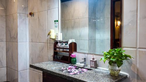 a bathroom with a sink and a mirror at Okay Boutique Hotel in Phnom Penh