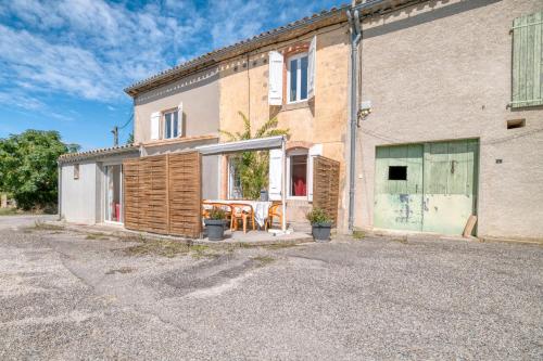 にあるGîte Le Rosier - Gîte À La Fermeの外にテーブルと椅子がある建物