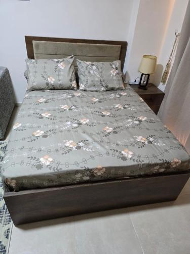 a bed with a gray bedspread with flowers on it at Golden Tiba in Hurghada