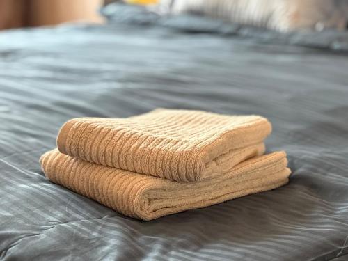 a stack of towels sitting on a bed at Cozy Apart in Center in Baku