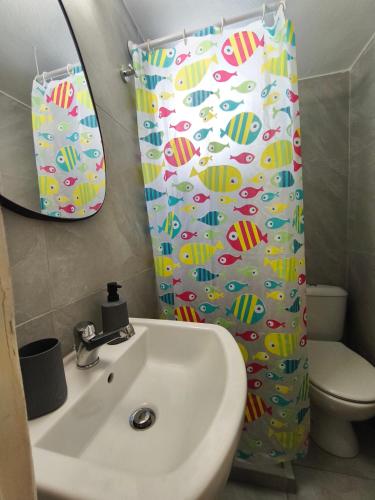 a bathroom with a sink and a shower curtain at Flya House in Athens