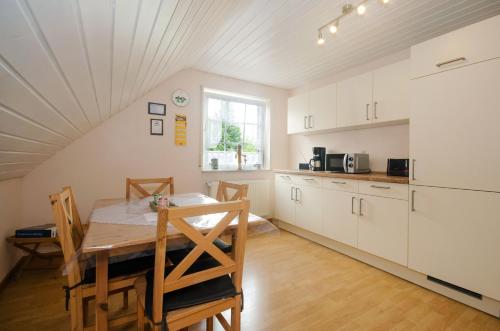 a kitchen and dining room with a table and chairs at Ferienwohnung Nordbrock, 65317 in Moormerland