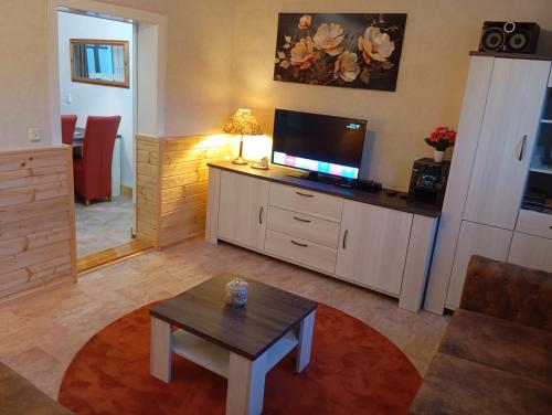 a living room with a tv and a coffee table at Ferienhaus Max Schmeling in Benneckenstein