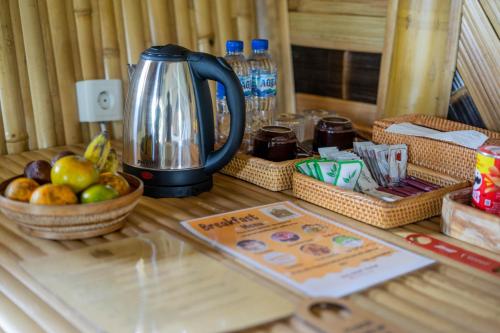 a table with a coffee pot and baskets of fruit at Velonia Iseh in Sidemen
