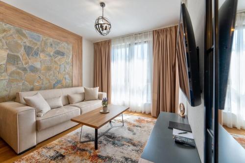 a living room with a couch and a tv at Mountain Pearl Zlatibor in Zlatibor