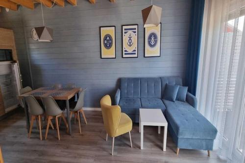 a living room with a blue couch and a table at Comfortable holiday homes, Sarbinowo in Sarbinowo