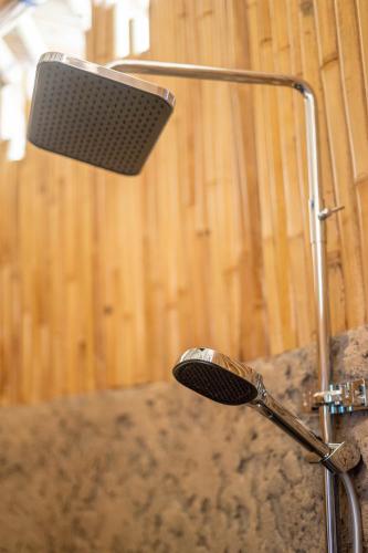 a shower head and a light in a bathroom at Velonia Iseh in Sidemen
