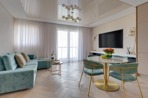 a living room with a blue couch and a table at Letnica Seaside by Downtown Apartments in Gdańsk