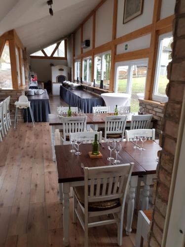 a dining room with wooden tables and white chairs at Das Gerhards in Wolfhagen