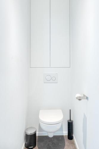 a white bathroom with a toilet and a shower at 4 Beautiful Apartments in the Center of Ieper in Ypres