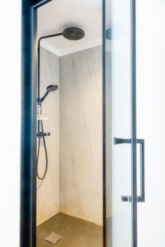 a shower with a shower head in a bathroom at 4 Beautiful Apartments in the Center of Ieper in Ypres